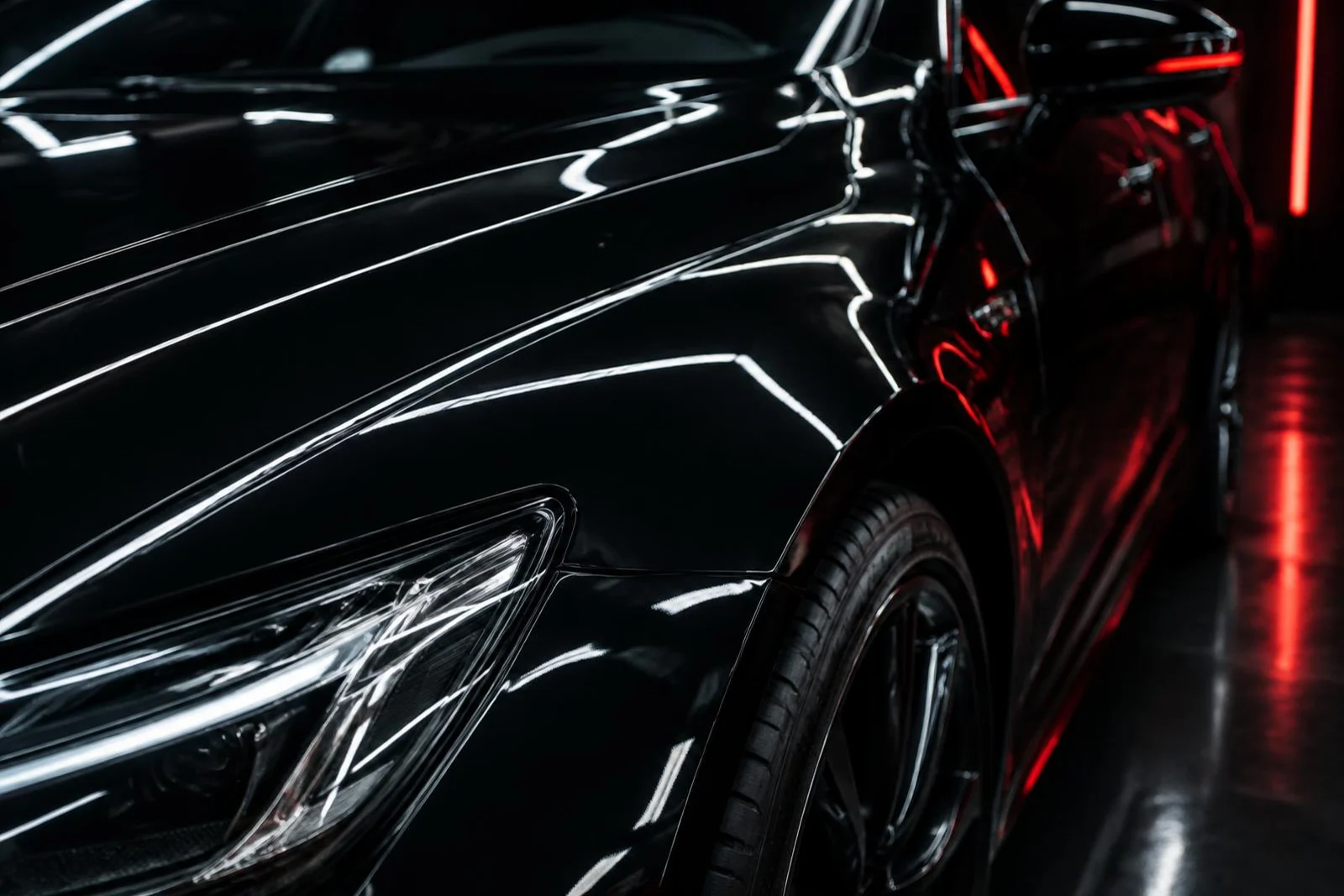 Freshly cleared black fender reflecting booth lights