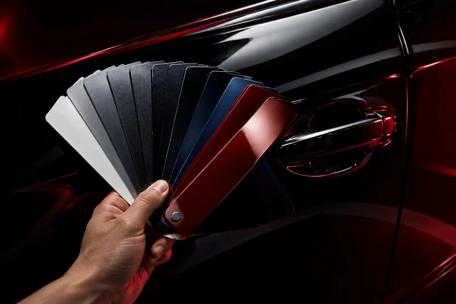 Paint color swatches held against a glossy car door